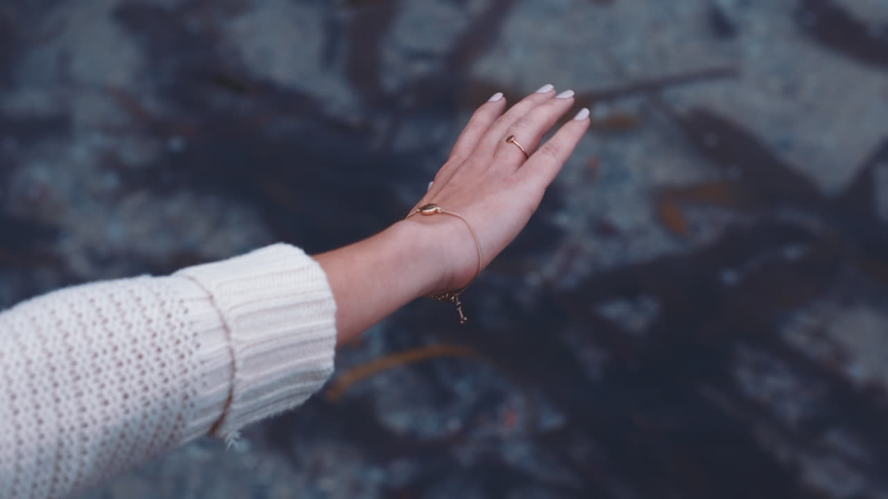 해변에 있는 바 ⁇ 물 위에 손을 흔들고 있는 여자