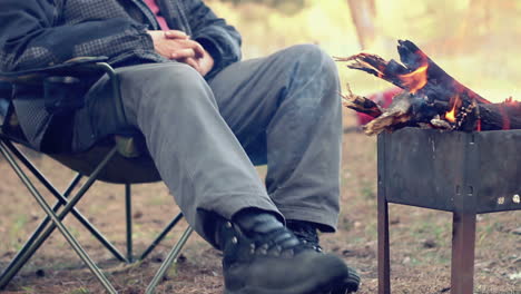 Turista-Sentado-En-Una-Silla-De-Campamento-Cerca-De-Una-Fogata.-Recreación-Al-Aire-Libre