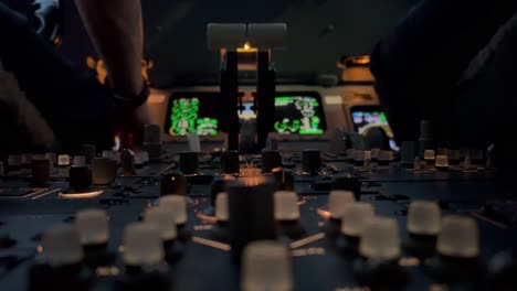 Close-view-of-a-jet-cockpit-during-a-night-flight-while-pilots-are-operating-sytems