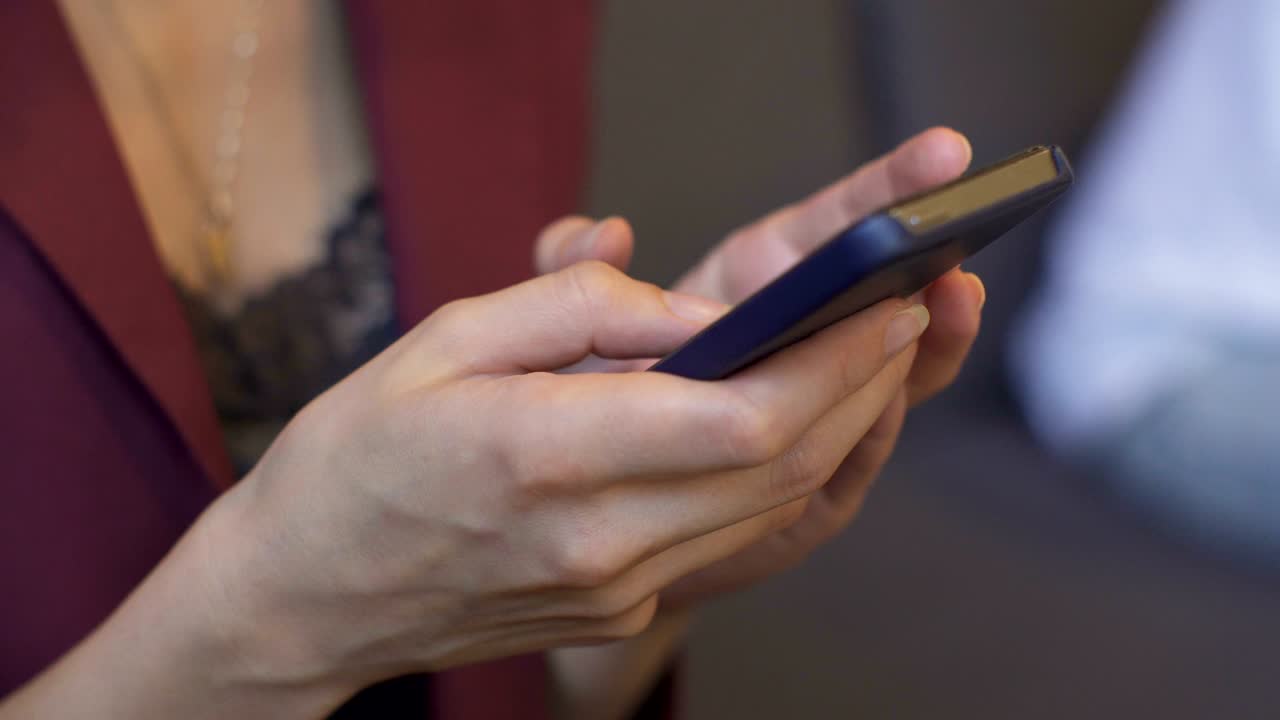 una mujer de negocios usando un teléfono inteligente en una cafetería.