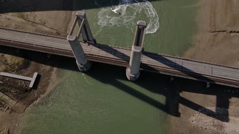 vista aérea de los coches que circulan por el puente kingsferry y una carrera de motos acuáticas en el pantano del sudeste de inglaterra