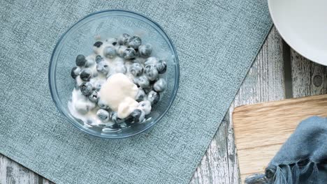 cerca de yogur fresco con bayas azules en un tazón