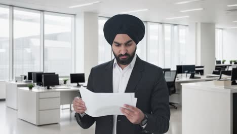 stressed sikh indian businessman reading company reports