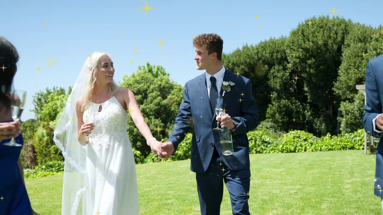 Fine del matrimonio, sposi che camminano tenendo in mano dei flûte attraverso il prato, con scintille che si sovrappongono alla scena.
