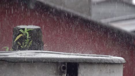 lluvia muy fuerte en una estructura frente a una pared roja