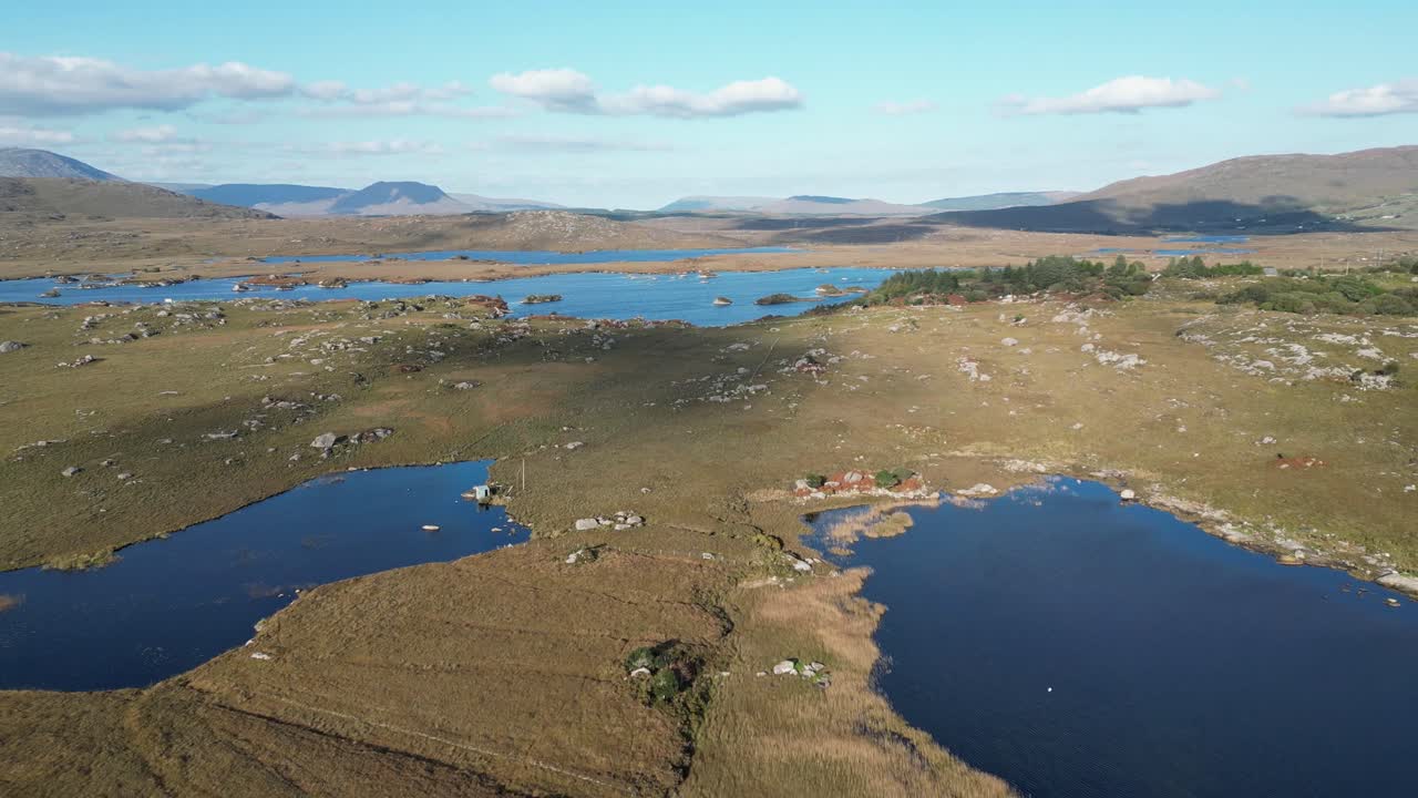 Drone aereo con panoramica lenta all'indietro su laghi e prati rurali a Galway, Irlanda.