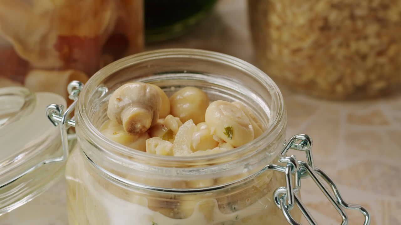 Fermented champignons, Jar with marinated mushrooms on wooden table, traditional salted marinated asian food.