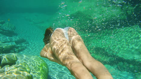 Mujer-En-Bikini-Blanco-Nadando-Bajo-El-Agua-En-Claro
