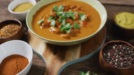 video of freshly prepared curry in bowl lying on board on wooden surface