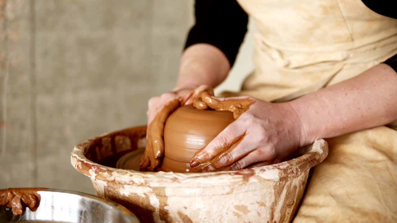 rueda de cerámica giratoria de cerca. pie de alfarero en pantalones negros trabajando en un taller de cerámica. hermosa joven trabajando en un jarrón en la clase maestra de cerámica. de cerca