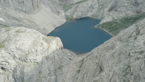 Glacier-lake-among-mountain-from-drone