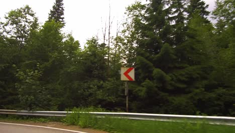 Slow-drive-on-a-winding-road-through-a-forest,-Bucegi-mountains,-Romania