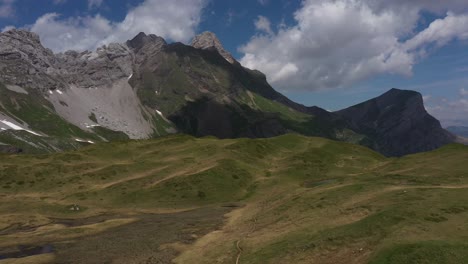 Dramatic-view-of-a-meadow-surrounded-by-cliffs-in-the-French-Alps