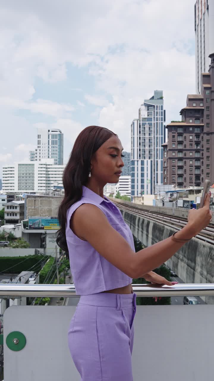 Woman in Purple Outfit with Mobile Phone in City