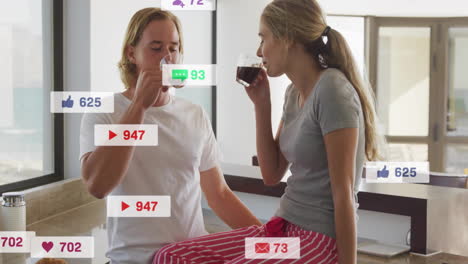 Animación-De-Notificaciones-De-Redes-Sociales-Sobre-Una-Pareja-Tomando-Café-En-Una-Cocina-Moderna