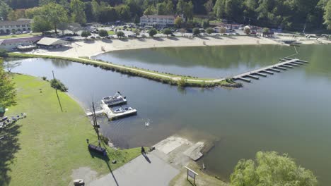 Vista-De-Drones-De-La-Playa-Del-Lago-Lure-Y-Del-Hotel-Con-Montañas-Al-Fondo