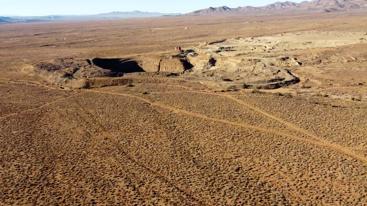 US, AZ, Kingman, Emerald Isle Mine, 2025-01-14 - Drone view of an open pit mine in the desert with equipment, tailings pile, at sunrise