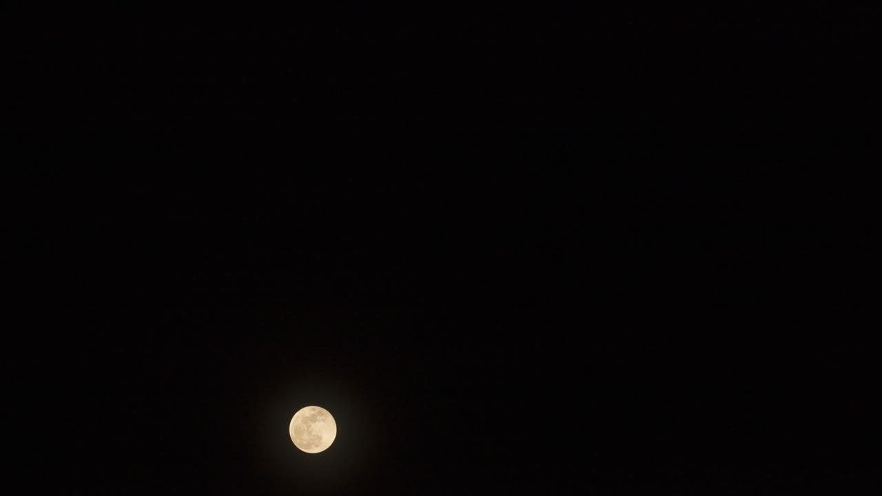 Time lapse of  supermoon (Full moon at largest) and also a partial lunar eclipse rising in dark sky.