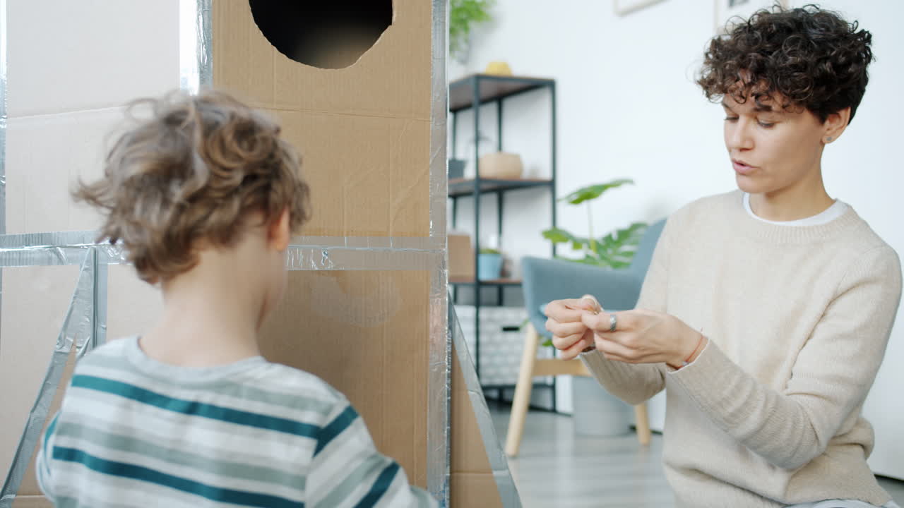 Mother and son building a cardboard rocket together