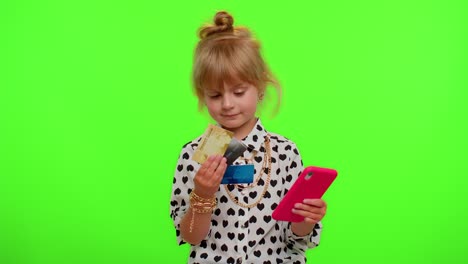 Little-teen-kid-child-girl-using-credit-bank-cards-and-smartphone-while-purchases-online-shopping