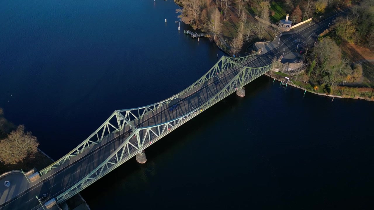 Auto che attraversano il Ponte di Glienicke sul fiume Havel in autunno. Incredibile ripresa aerea con drone dall'alto.