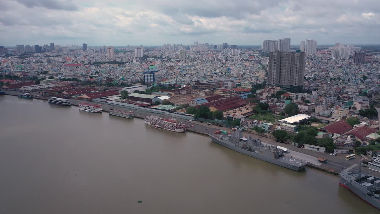 Aerial orbit shot of river port with navy ships and tourist boats