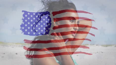 Animation-of-flag-of-united-states-of-america-over-biracial-woman-on-beach