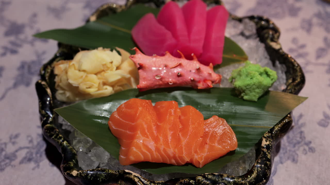 Close up of tuna and salmon sashimi on banana leaves on ice