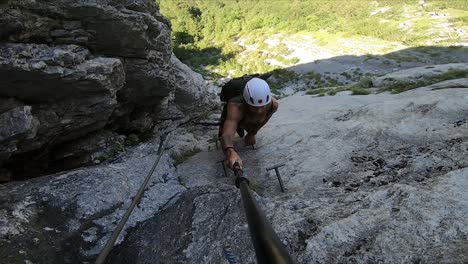 Joven-Blanco-Escalando-Una-Ladera-Empinada-De-Una-Montaña,-Mirando-La-Hermosa-Vista-Con-Asombro-Y-Sintiéndose-Libre-Y-Feliz-En-Su-Aventura-Extrema-En-Suiza