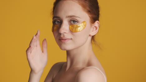 Redheaded-girl-in-front-of-camera-on-yellow-background.