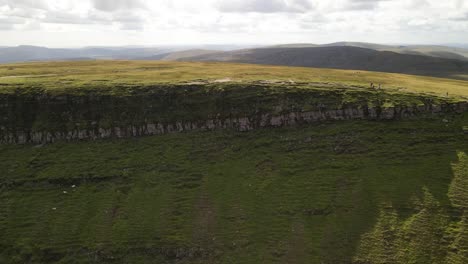 Shimmering-idyllic-blue-mountain-valley-lake-Llyn-y-fan-Fach-Brecon-beacons-aerial-pull-back-reveal-view