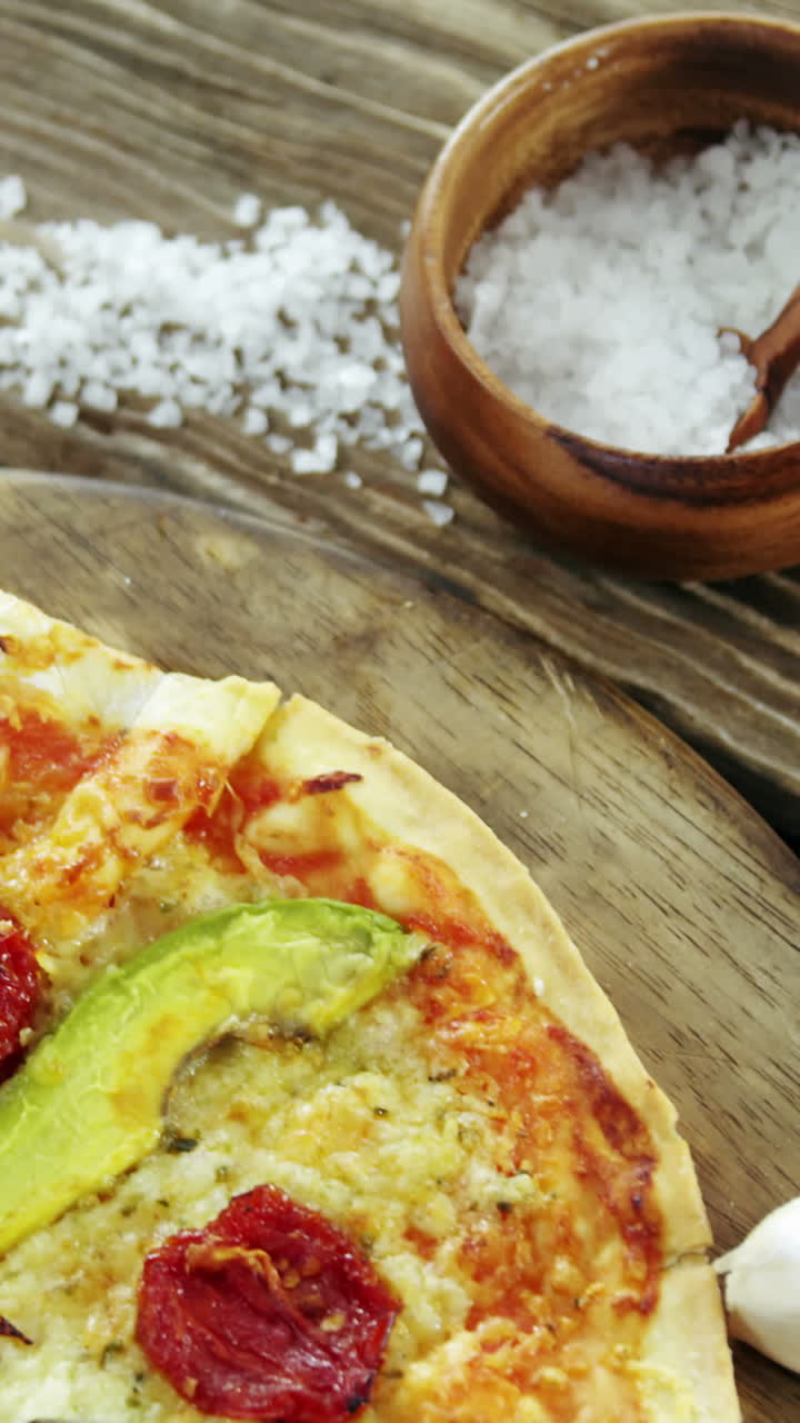 pizza italiana en una mesa de madera con verduras y especias