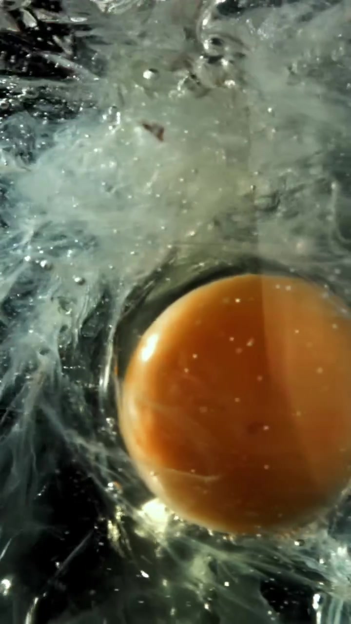 Slow Motion Egg Yolk and White Dropping into Water
