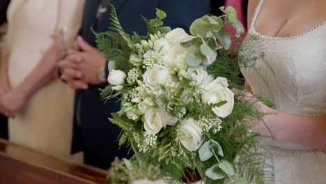 Wedding-bouquet-held-by-the-bride-during-the-wedding-ceremony-in-the-church