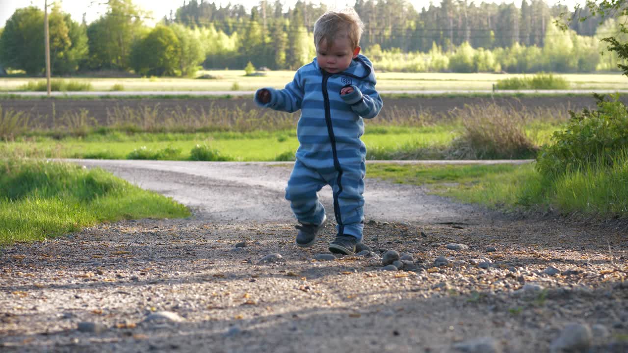 niño pequeño da los primeros pasos y aprende a caminar al aire libre