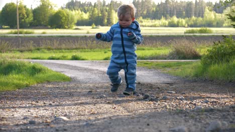 niño pequeño da los primeros pasos y aprende a caminar al aire libre