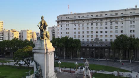 Aerial-orbit-of-bronze-Monument-of-Two-Congresses-in-square-in-front-of-Argentine-Congress-Palace-at-sunset,-Buenos-Aires