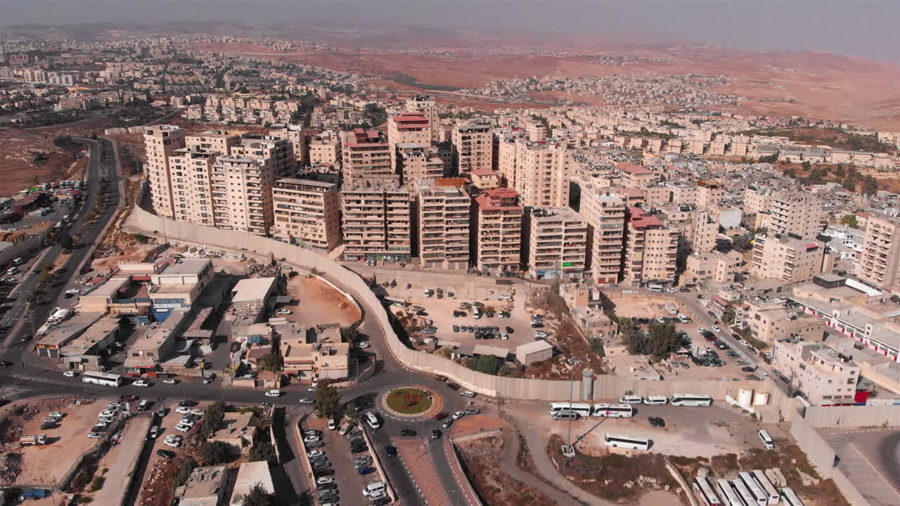 Filmato aereo di una città dietro un muro di cemento con torretta di avvistamento militare