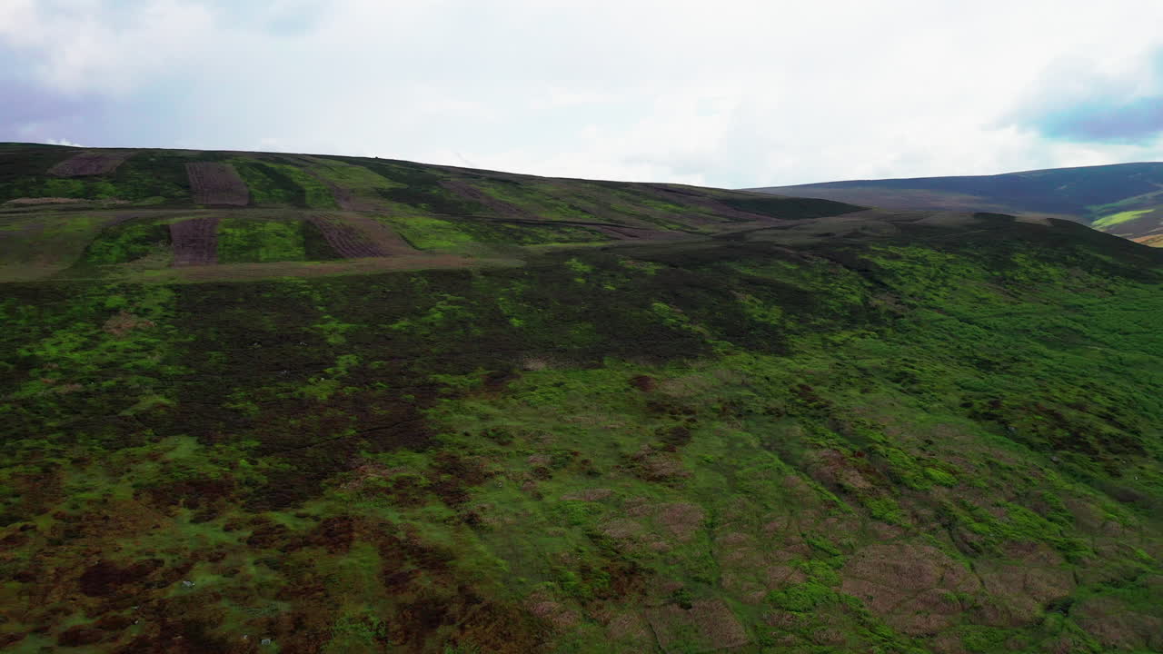 toma aérea hacia atrás de la ranura de una colina empinada en el distrito inglés de los lagos, brillante día de verano
