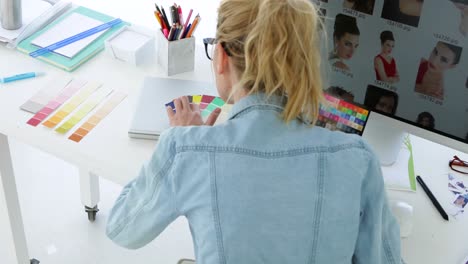 rear view of blonde designer working at her desk