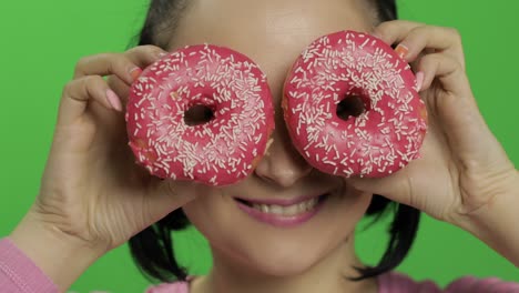 feliz joven hermosa posando y divirtiéndose con rosquillas. llave de croma