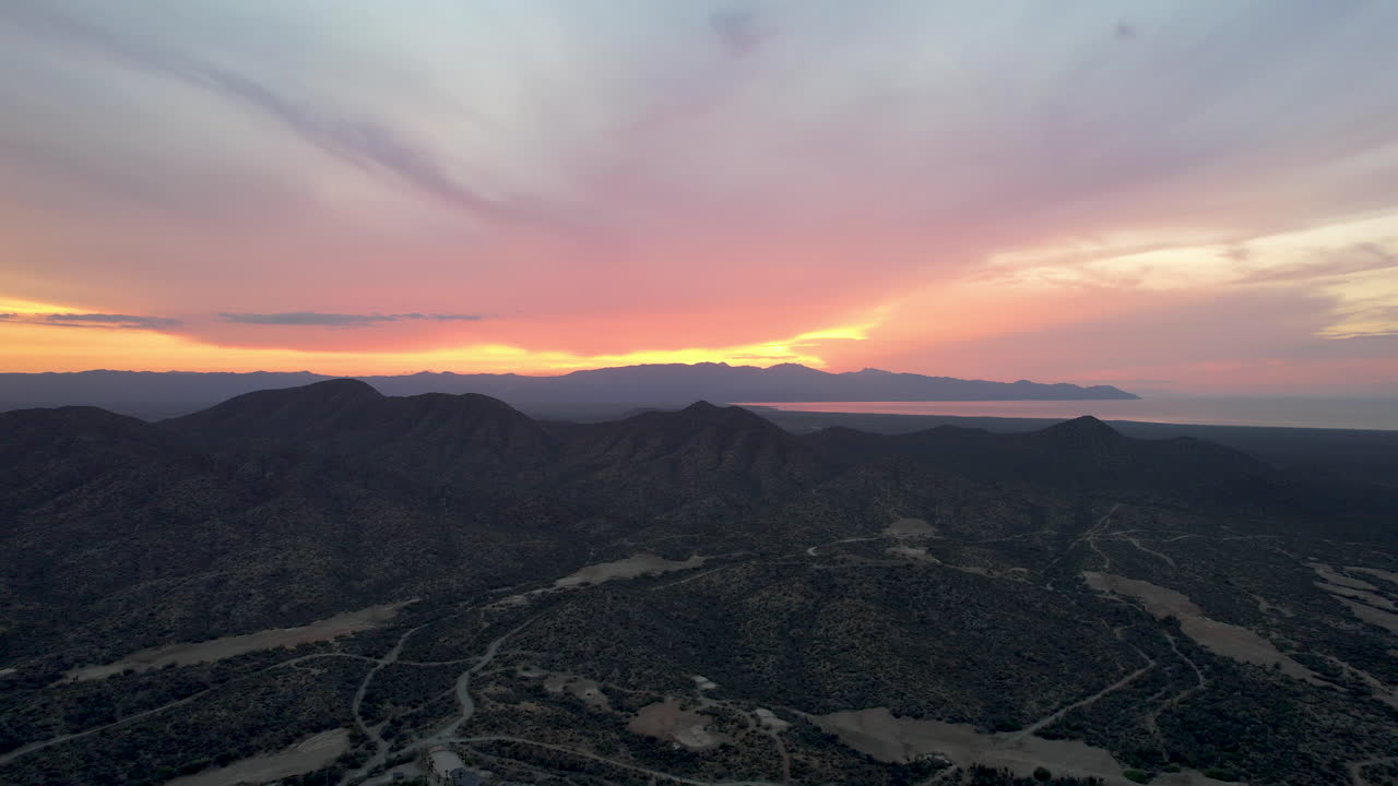 drone shot tipo dronie de los rayos del sol al atardecer en los cabos mexico