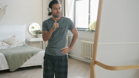 man dancing in bedroom with headphones