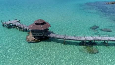 Luftaufnahme-Eines-Pavillons-Auf-Einem-Dock-Draußen-Im-Meer-Auf-Den-Felsen