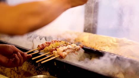 preparing skewers on a smoky charcoal grill