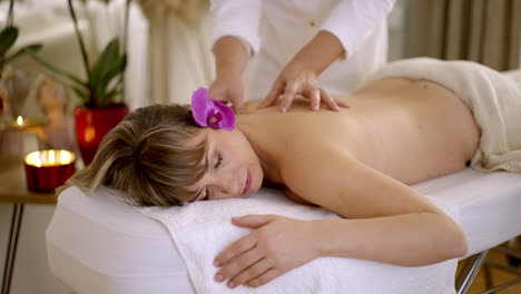 una mujer recibiendo un masaje de espalda en un spa.