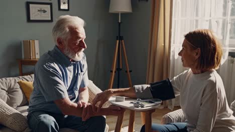 elderly couple checking blood pressure at home