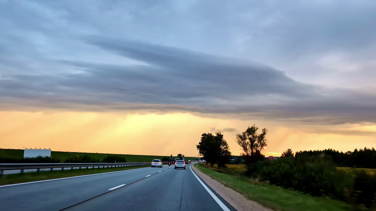 Road traffic at sunset, clouds dispersing