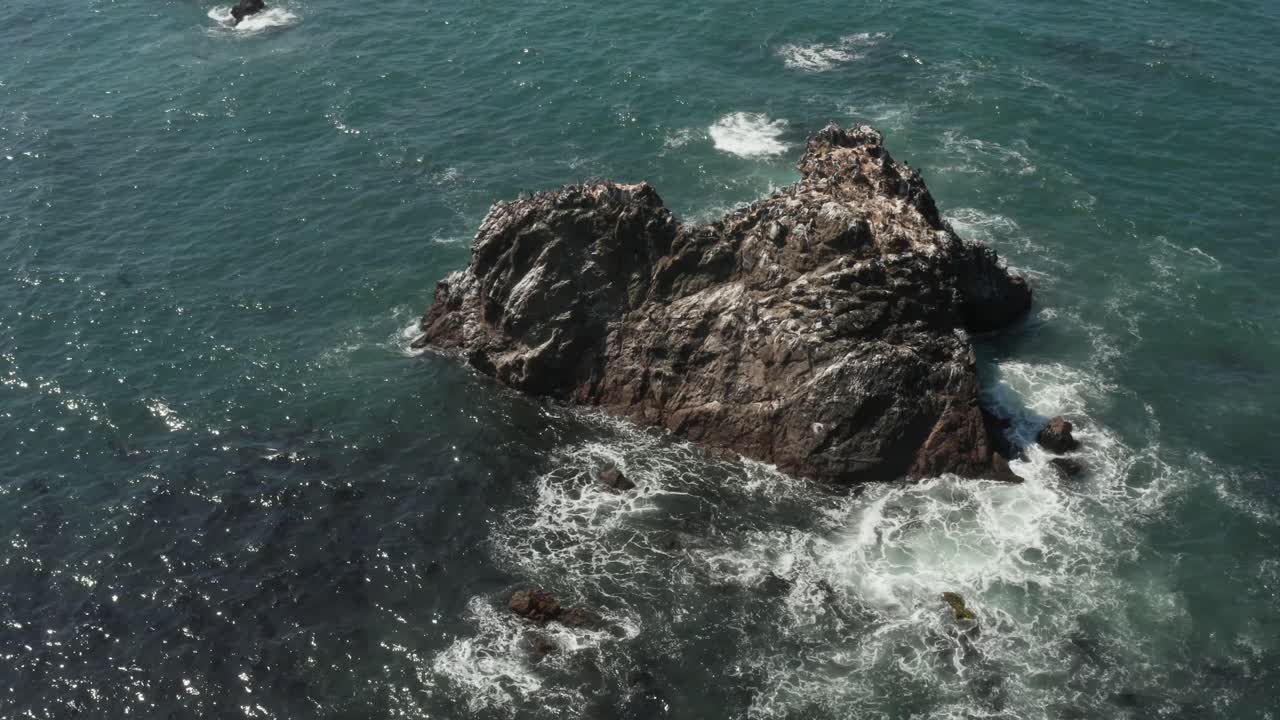 Uccelli posati su Arched Rock nell'oceano con onde che si infrangono vicino alla spiaggia di Bodega Bay sulla Highway 1 nella California settentrionale