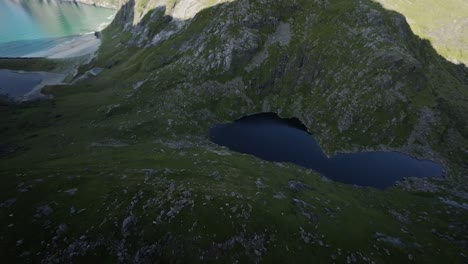 Filmische-Fpv-drohnenaufnahme,-Stabilisiert-Von-Den-Lofoten,-Die-Einen-Berg-Hinunter-In-Richtung-Eines-Bergsees-Tauchen